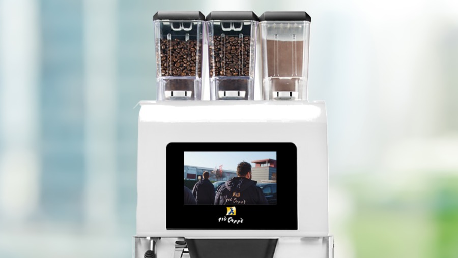 Piu 600 mit buntem Hintergrund, auf dem Bildschirm der Maschine ist der Imagefilm von piu caffe