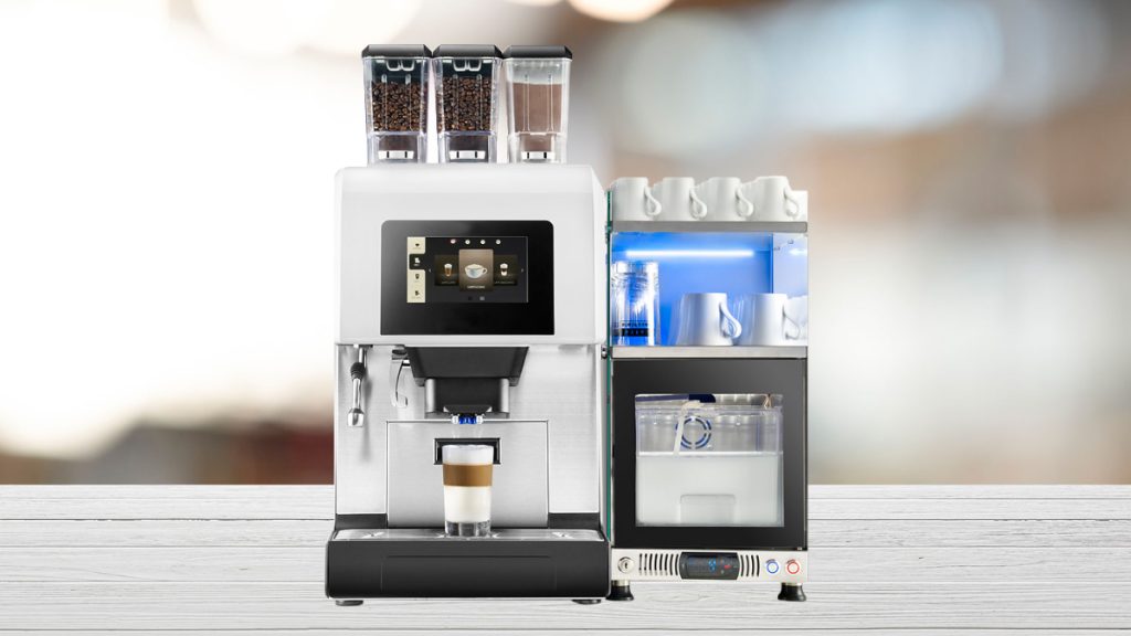Der Kaffeevollautomat più 600+ auf einem grauen Tisch von vorne. Der Hintergrund ist weichgezeichnet.